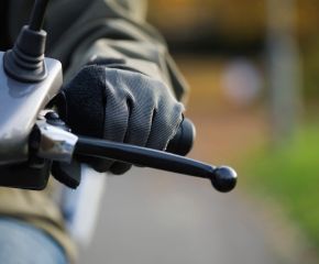 photo de la main d'une personne sur le guidon d'un scooter