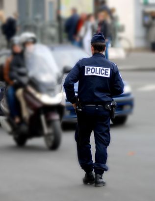 Policier se dirigeant vers un scooter pour un controle